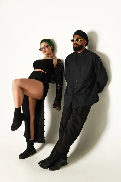 Um jovem casal elegante mostra seu estilo único em um ambiente de estúdio, irradiando confiança. — Fotografia de Stock