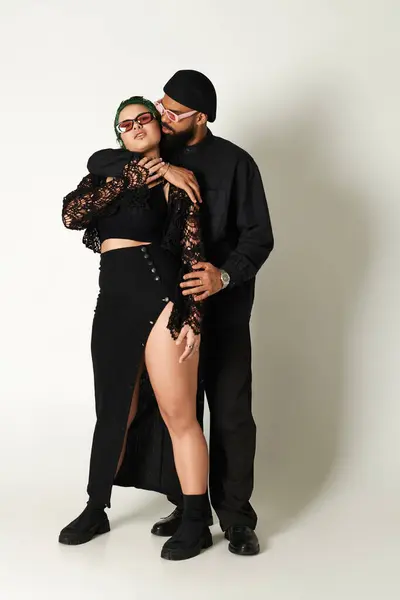 Um casal elegante posa em um estúdio, mostrando sua moda e conexão lúdica. — Fotografia de Stock