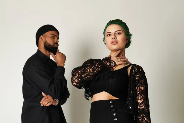 Young couple showcases their unique fashion sense while posing in a modern studio space — Stock Photo