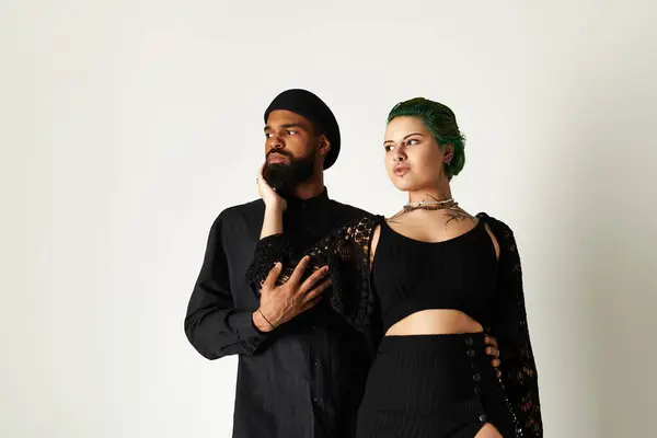 A stylish young couple poses together in a studio, flaunting their outfits — Stock Photo