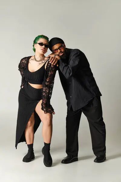 A young couple showcases their unique styles while posing confidently in a chic studio. — Stock Photo