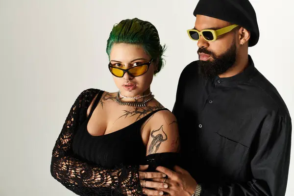 In uno studio vivace, una coppia alla moda mette in mostra il loro stile unico mentre posa con fiducia. — Foto stock