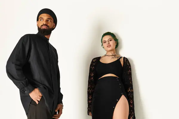 Casal jovem mostra seu estilo vibrante em um estúdio moderno, exalando confiança e charme. — Fotografia de Stock