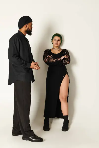 Um jovem casal elegante mostra seus estilos únicos em um estúdio moderno, exalando confiança. — Fotografia de Stock