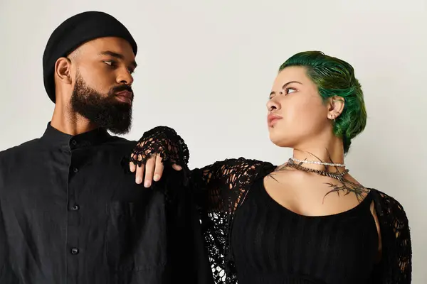 A stylish multicultural couple poses in trendy and unique outfits. — Stock Photo