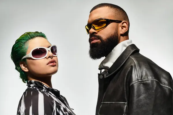 Young couple displays their trendy outfits and unique style while wearing sunglasses indoors. — Stock Photo