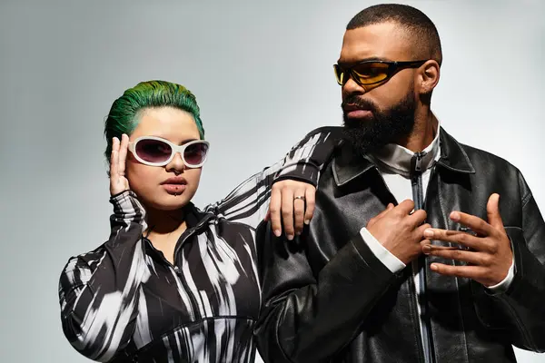 A fashionable couple poses confidently in sunglasses, celebrating diversity and unique style. — Stock Photo