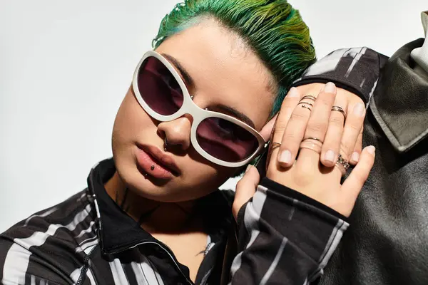 A stylish young couple dons trendy sunglasses, showcasing their vibrant outfits while posing. — Stock Photo