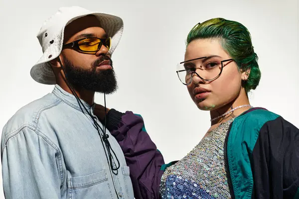 A young couple in trendy outfits poses confidently in sunglasses, celebrating diversity. — Stock Photo