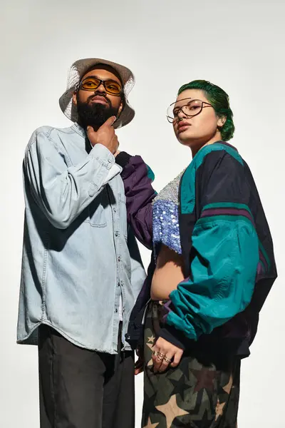 A fashionable young couple showcases their unique style in a vibrant studio, exuding confidence. — Stock Photo