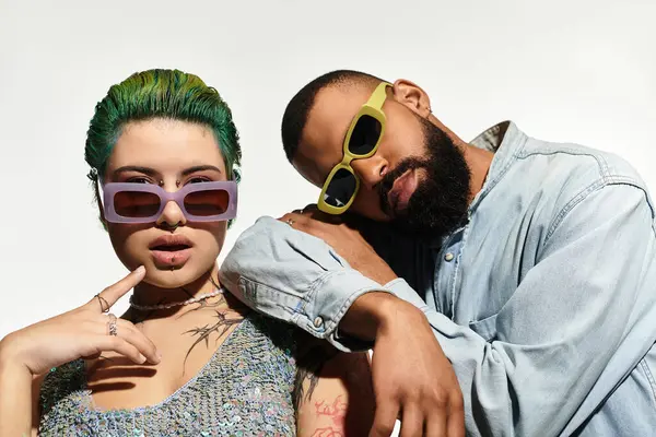 A stylish couple shows off their trendy sunglasses while embracing each other. — Stock Photo