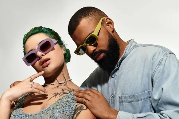 Casal elegante posa em óculos de sol, apresentando suas roupas vibrantes e diversidade. — Fotografia de Stock