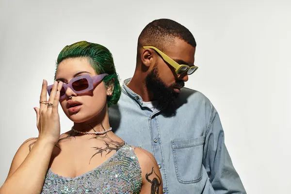 A fashionable couple poses confidently in sunglasses, embodying style and diversity. — Stock Photo