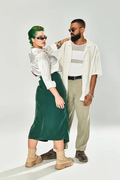 A young multicultural couple poses confidently in a studio, showing off their stylish looks. — Stock Photo