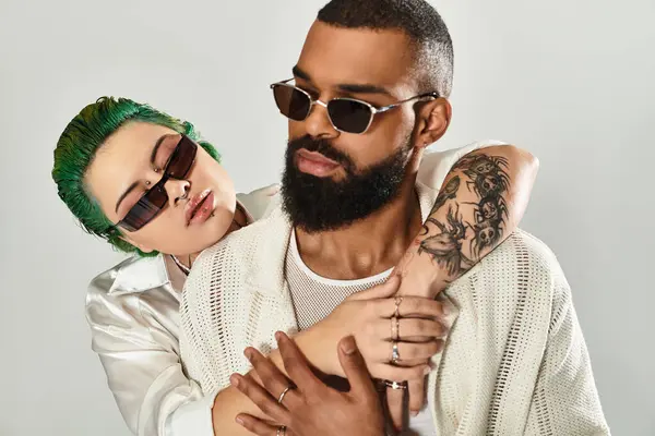 A fashionable young couple embraces in a studio, showcasing their vibrant style and love. — Stock Photo