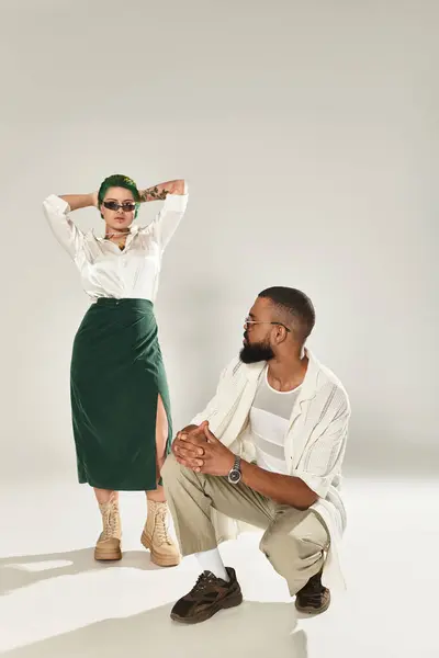Fashionable multicultural couple posing in stylish sunglasses in a studio. — Stock Photo
