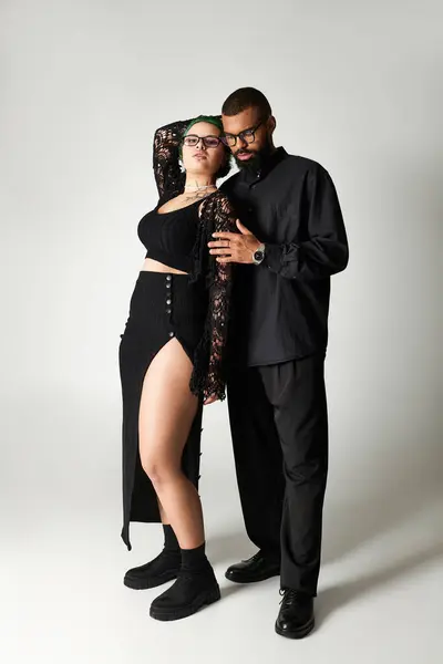 Um casal elegante posa confiantemente em um estúdio, exibindo suas roupas da moda. — Fotografia de Stock