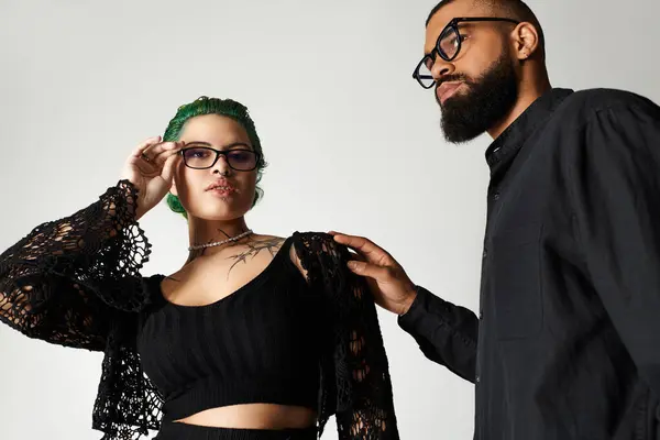 Um jovem casal multicultural exibe seu estilo único enquanto usa óculos de sol em um estúdio. — Fotografia de Stock