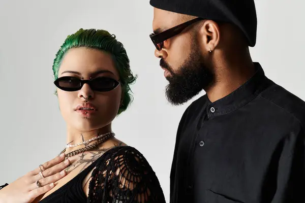 A stylish multicultural couple confidently shows off their striking outfits and sunglasses. — Stock Photo