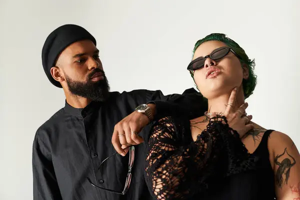 Jovem casal diverso mostra seu estilo único enquanto posando confiantemente em um estúdio. — Fotografia de Stock
