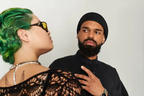 Young couple showcases their unique style with vibrant sunglasses in a creative studio setting. — Stock Photo