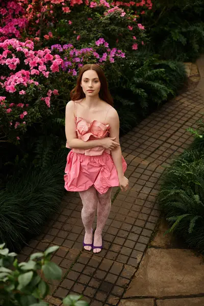 Delicate flowers surround a young womans charm in a lush, tranquil greenhouse — Stock Photo