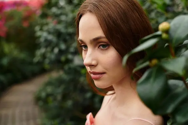 A young woman stands gracefully amidst lush greenery, appreciating the tranquility of nature. — Stock Photo