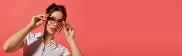 Femme confiante ajuste ses lunettes élégantes dans un contexte lumineux, charme rayonnant. — Photo de stock