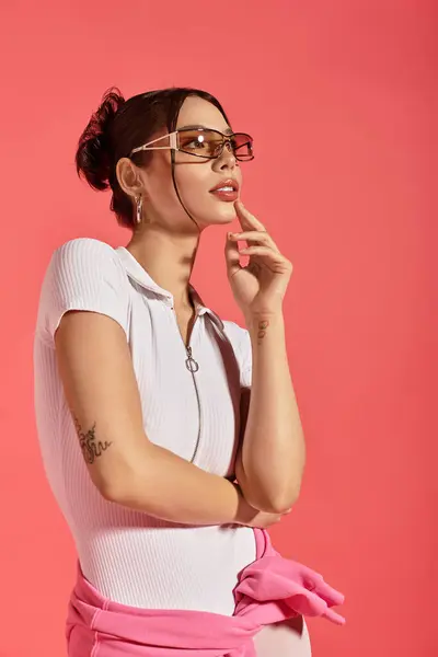 A young woman exudes elegance and charm while posing against a vibrant pink backdrop. — Stock Photo