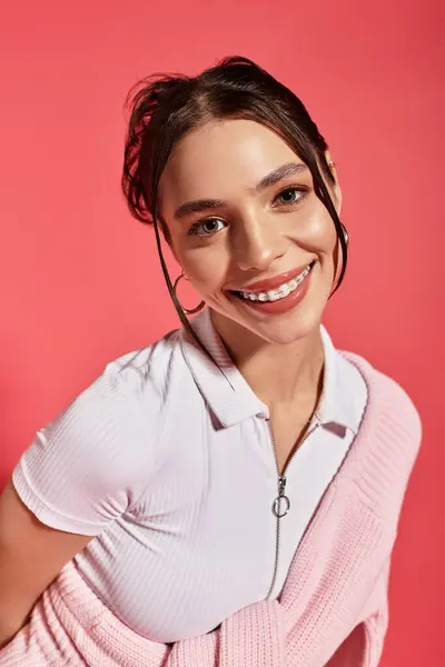 Beautiful young woman radiates happiness while posing in a stylish outfit against pink backdrop. — Stock Photo