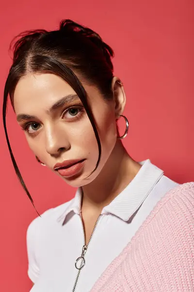 Uma jovem mulher confiante mostra sua beleza e estilo em um cenário rosa vibrante, exalando charme. — Fotografia de Stock