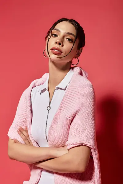 Beauty shines through as a young woman poses confidently in a chic outfit against a pink backdrop. — Stock Photo