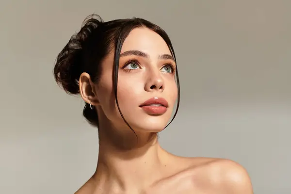 A striking young woman gazes upward, exuding inner strength and beauty with flawless skin. — Stock Photo