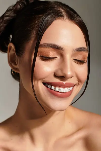 Una giovane bella donna trasuda felicità e fiducia con un sorriso radioso in una luce soffusa. — Foto stock