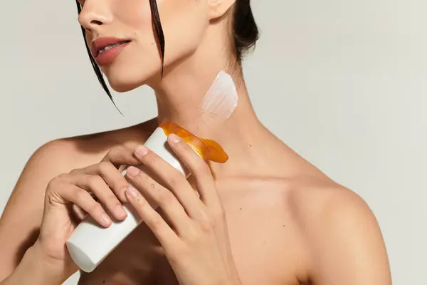 Young woman applies skin care to her neck, focusing on rejuvenation and radiance. — Stock Photo