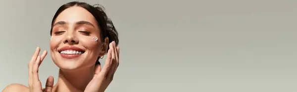Femme joyeuse embrasse sa routine de soins de la peau, rayonnant de beauté et de confiance en la tranquillité. — Photo de stock