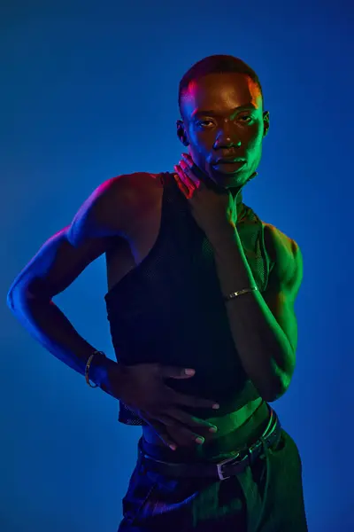 Un joven afroamericano muestra un atuendo elegante, irradiando confianza en medio de ricos colores. — Stock Photo