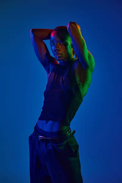 A confident young man poses in stylish attire against a colorful backdrop. — Stock Photo