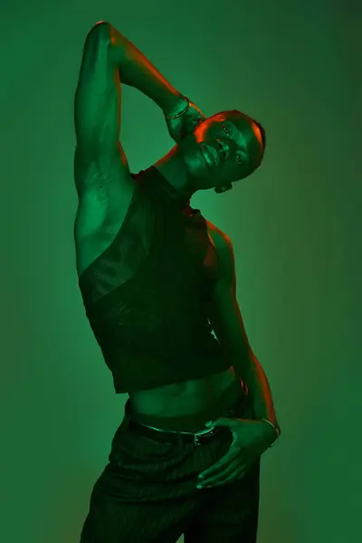 Un joven afroamericano en una pose feroz exhibe ropa elegante. - foto de stock