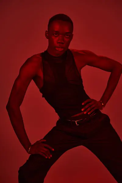 A young african american man in a sleek outfit strikes a bold pose, radiating confidence and style. — Stock Photo