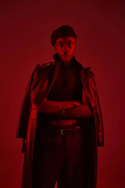 A young african american man shows off his vibrant style and confidence in a bold red setting. — Stock Photo