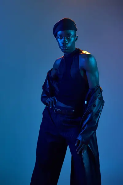 A young african american man poses confidently in stylish attire under twilight hues. — Stock Photo
