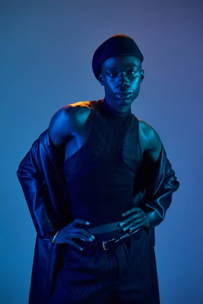 A young african american man exudes confidence in a vibrant outfit against a dynamic backdrop. — Stock Photo