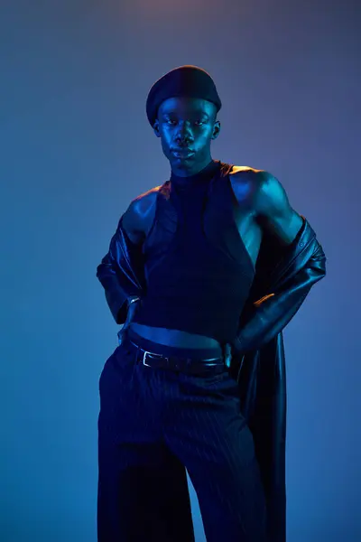 A young african american man poses confidently in chic blue attire, radiating flair and energy. — Stock Photo