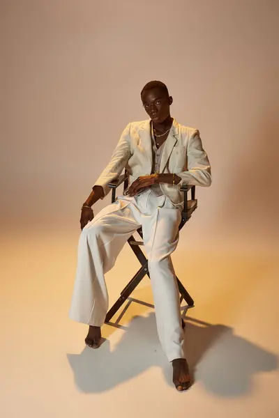 A confident young man poses in stylish attire, exuding charm against a minimalist background. — Stock Photo