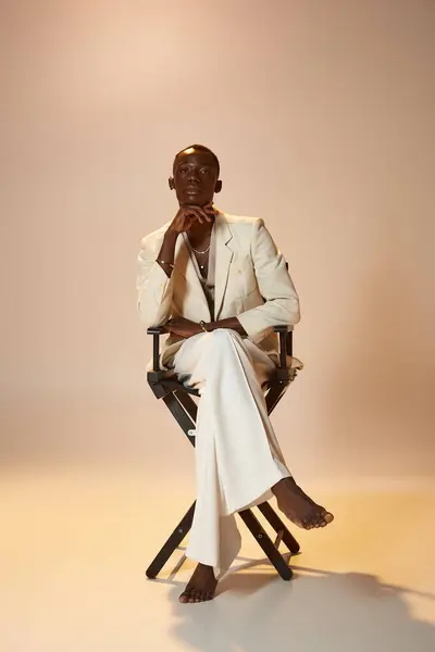 Stylish young african american man poses confidently in elegant attire inside a creative studio. — Stock Photo