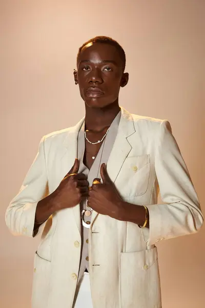 A young African American man stands tall in stylish attire, exuding charm in a bright studio. — Stock Photo
