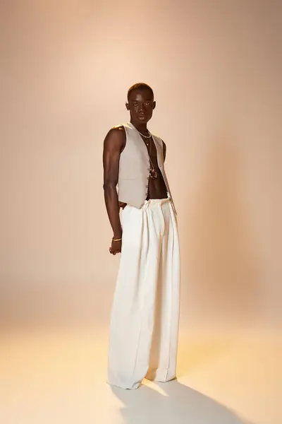 A young african american man showcases unique fashion with elegance in a softly lit environment — Stock Photo