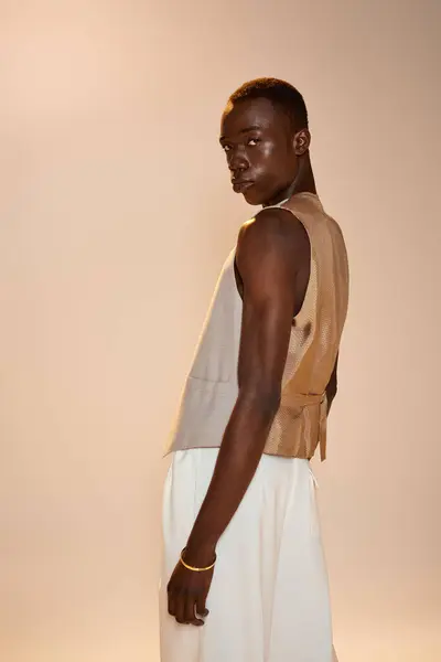 Un jeune homme afro-américain élégant se tient avec confiance dans un espace conçu de manière créative. — Photo de stock