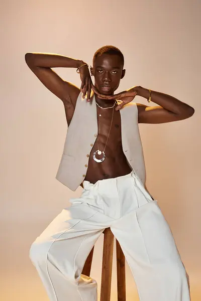 A young african american man poses confidently in stylish clothing against a simple backdrop. — Stock Photo